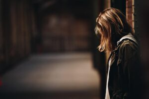 Young woman in dark street looking unhappy